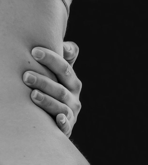 A hand pressing into the muscles at the base of the neck