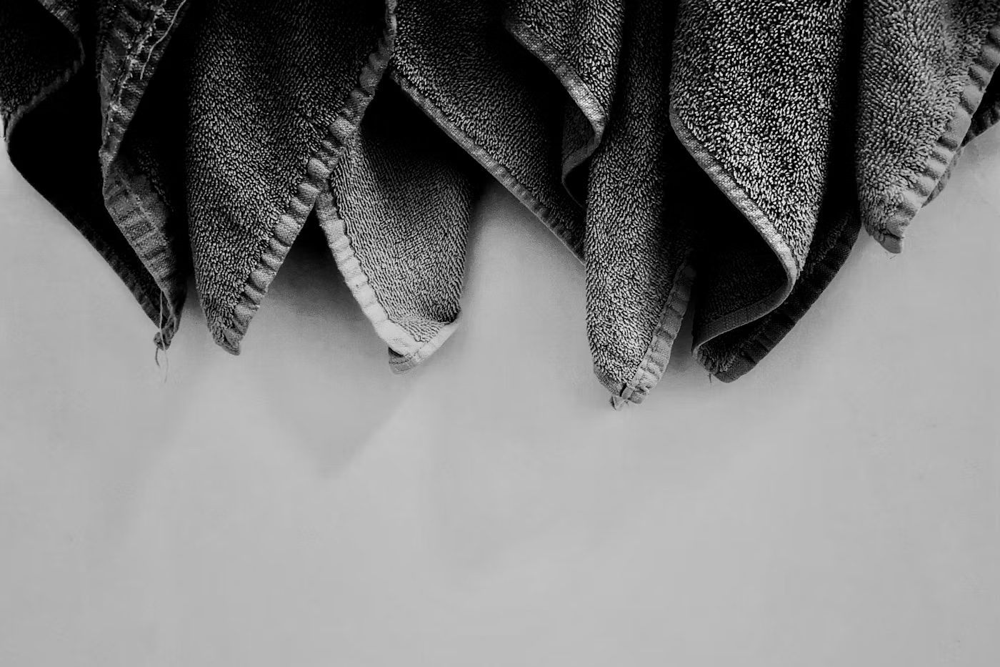 Soft towels hanging against a pale wall
